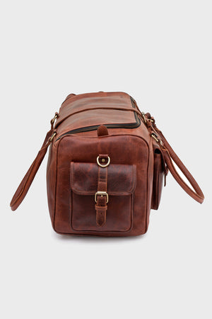 Side profile of the Cognac duffel bag with buckled flap pocket