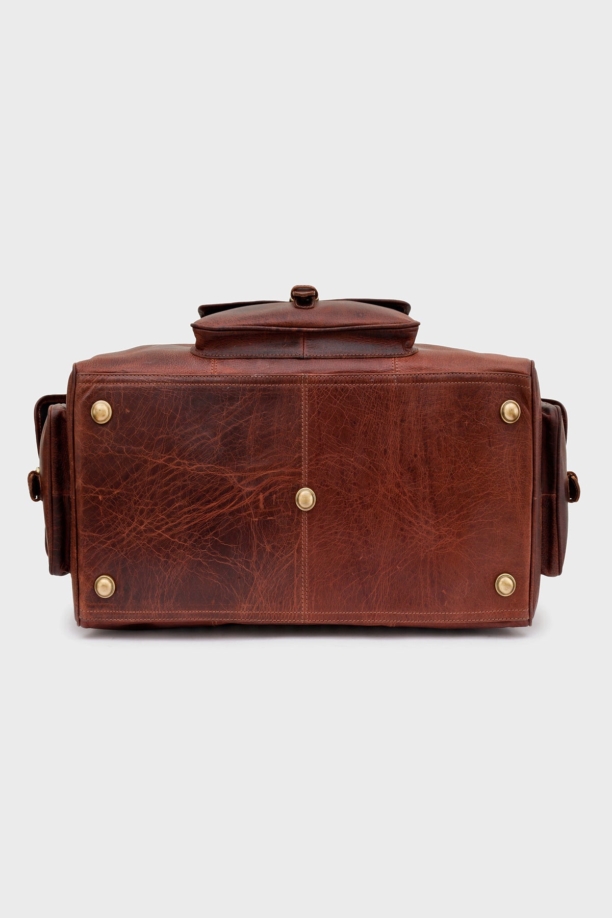 Base of the Cognac duffel bag showing protective brass studs