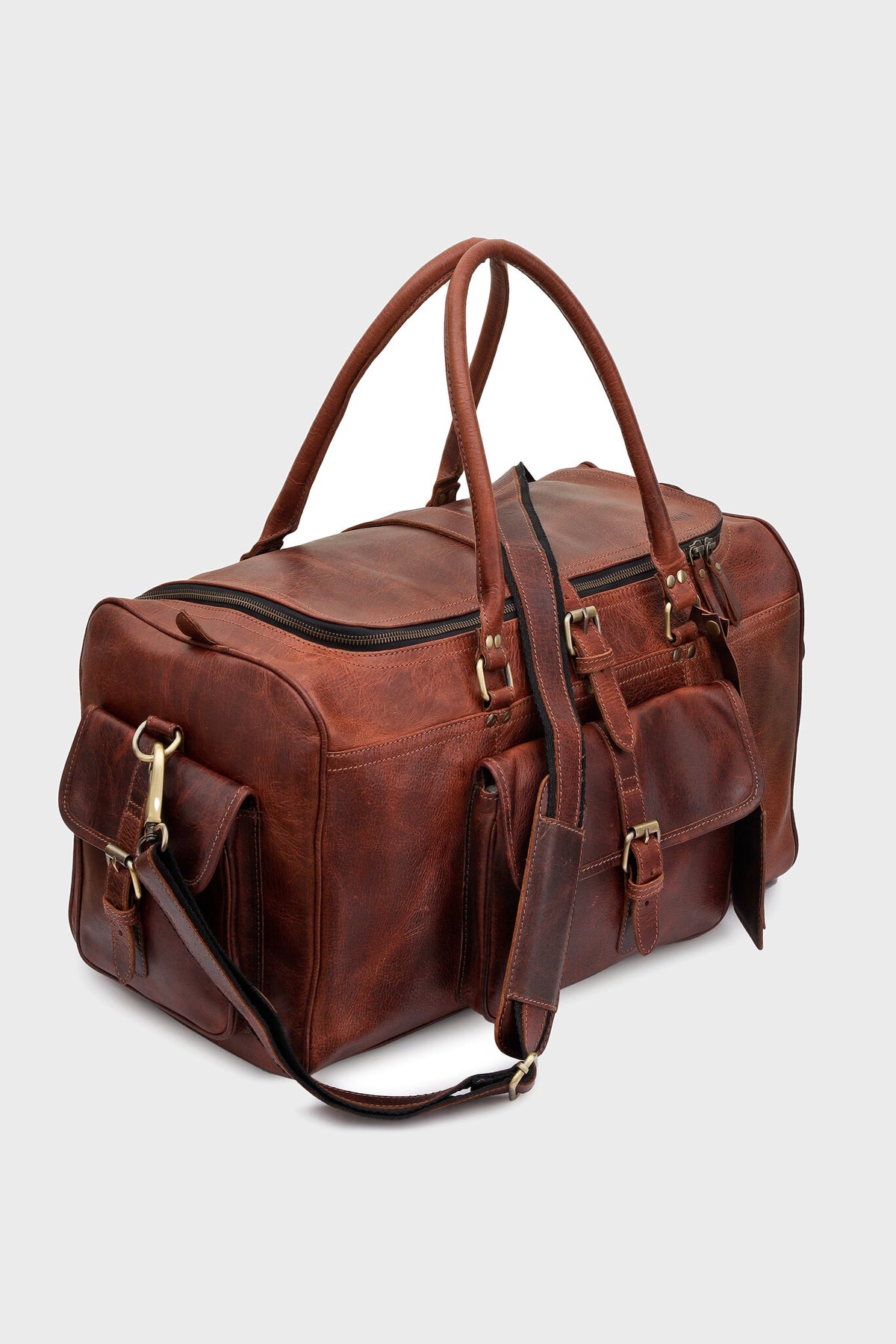 Cognac leather duffel bag showing front and side flap pockets