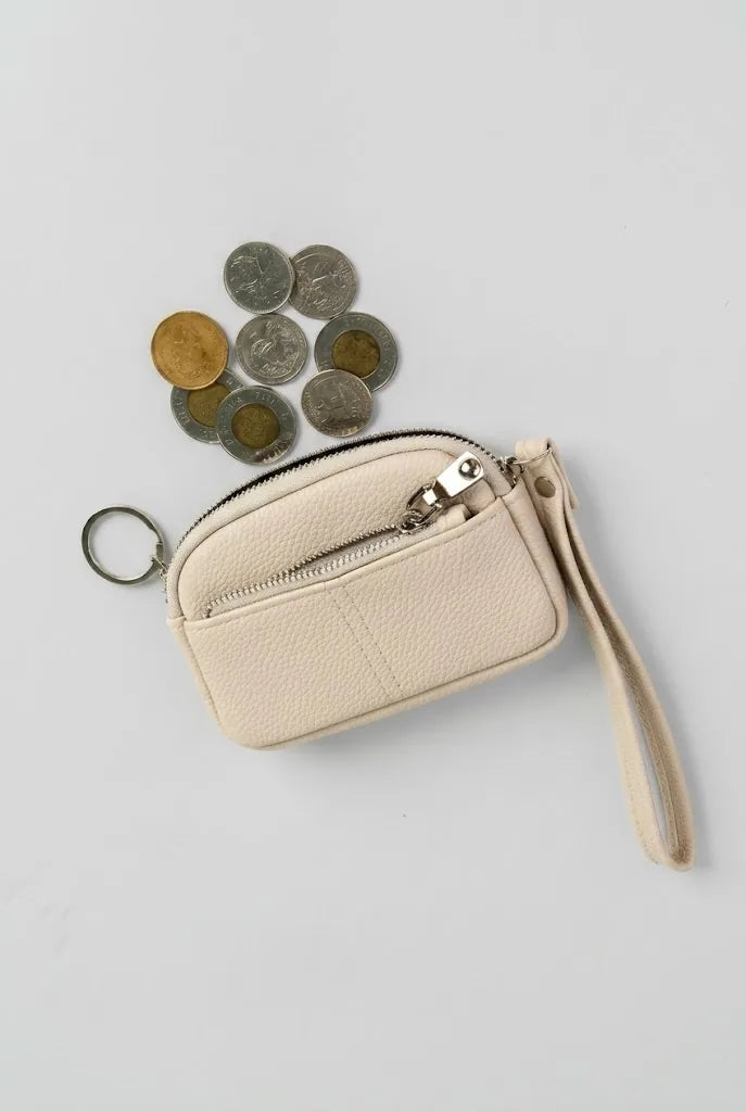 Beige coin pouch wristlet with coins and wrist strap